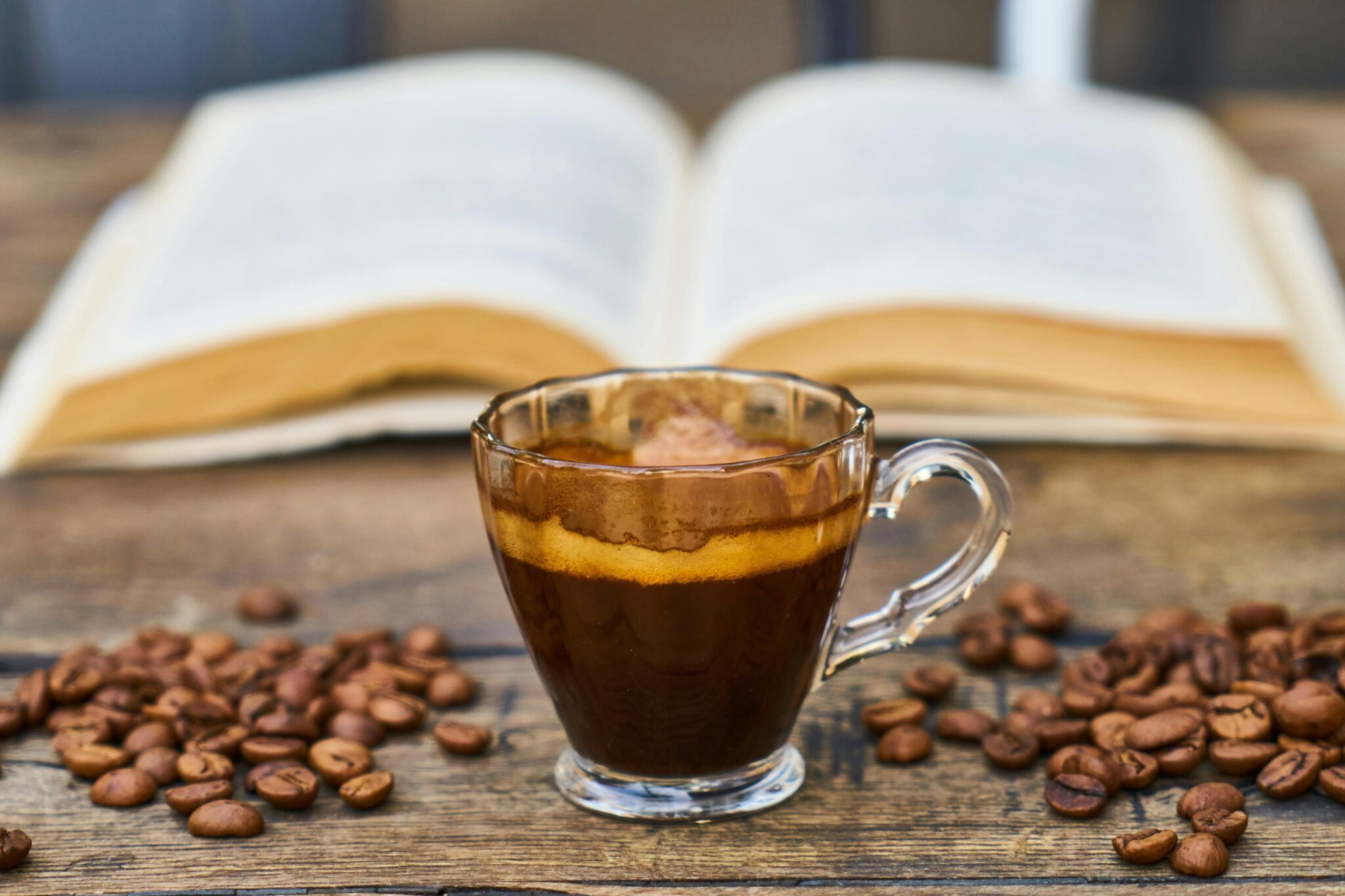 A rich espresso cup surrounded by beans and an open book, perfect for a relaxing break.